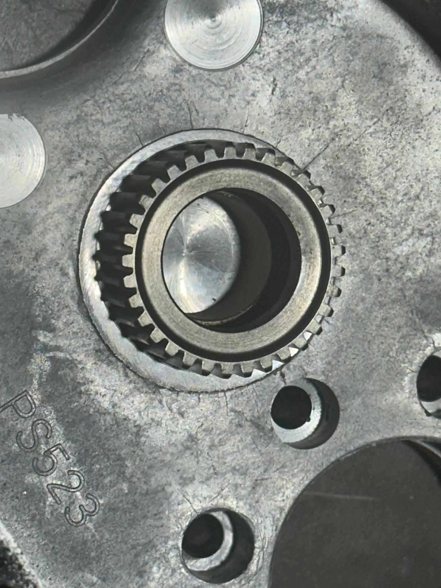 Close-up of a metallic gear mechanism, symbolizing precision engineering, with PIERCE Transfer Housing | 654 Series | 12,500 lbs engraved.