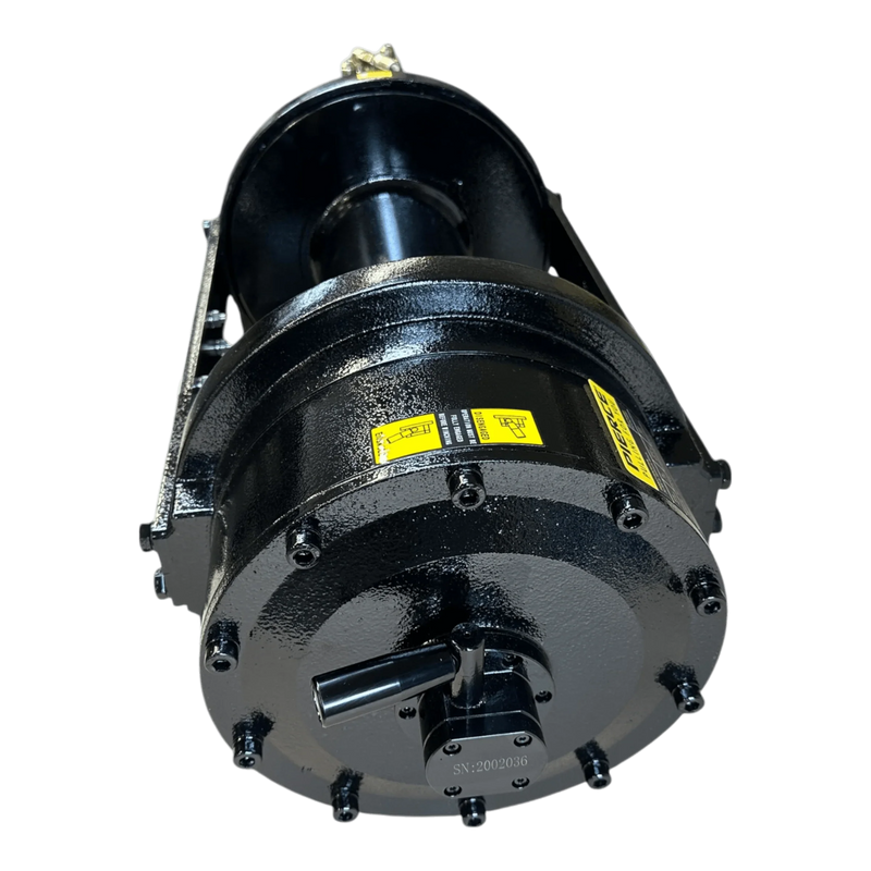 The Internal - Pierce Assembly Team’s 20,000 lb Hydraulic Recovery Winch (Long Drum, Manual Clutch) features a black industrial drum with bolts and yellow caution labels, viewed from a low front angle.