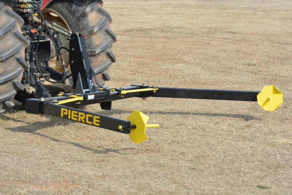 A black and yellow 3-Point Hay Bale Unroller by Internal - Pierce Assembly Team sits on dry grass, designed for efficient round bale handling.