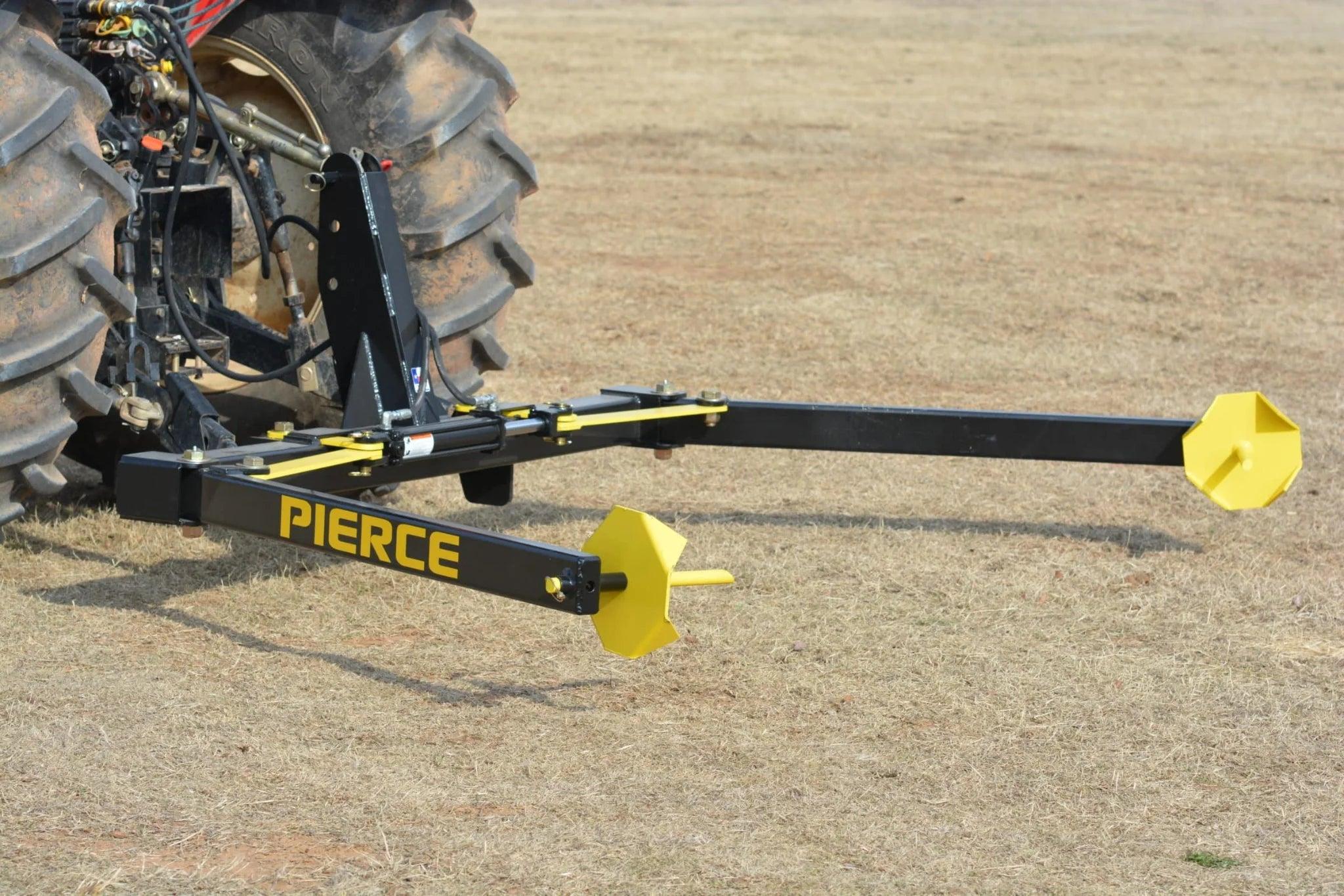 A PIERCE 3-Point Hay Bale Unroller with a yellow and black attachment sits on dry grass, ready to effortlessly tackle large round bales.