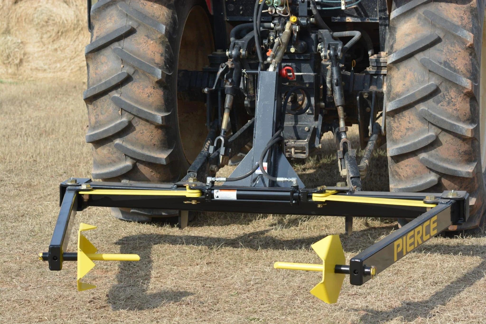 A tractor equipped with the Internal - Pierce Assembly Team 3-Point Hay Bale Unroller is used for rolling and laying irrigation pipes across a dry field.