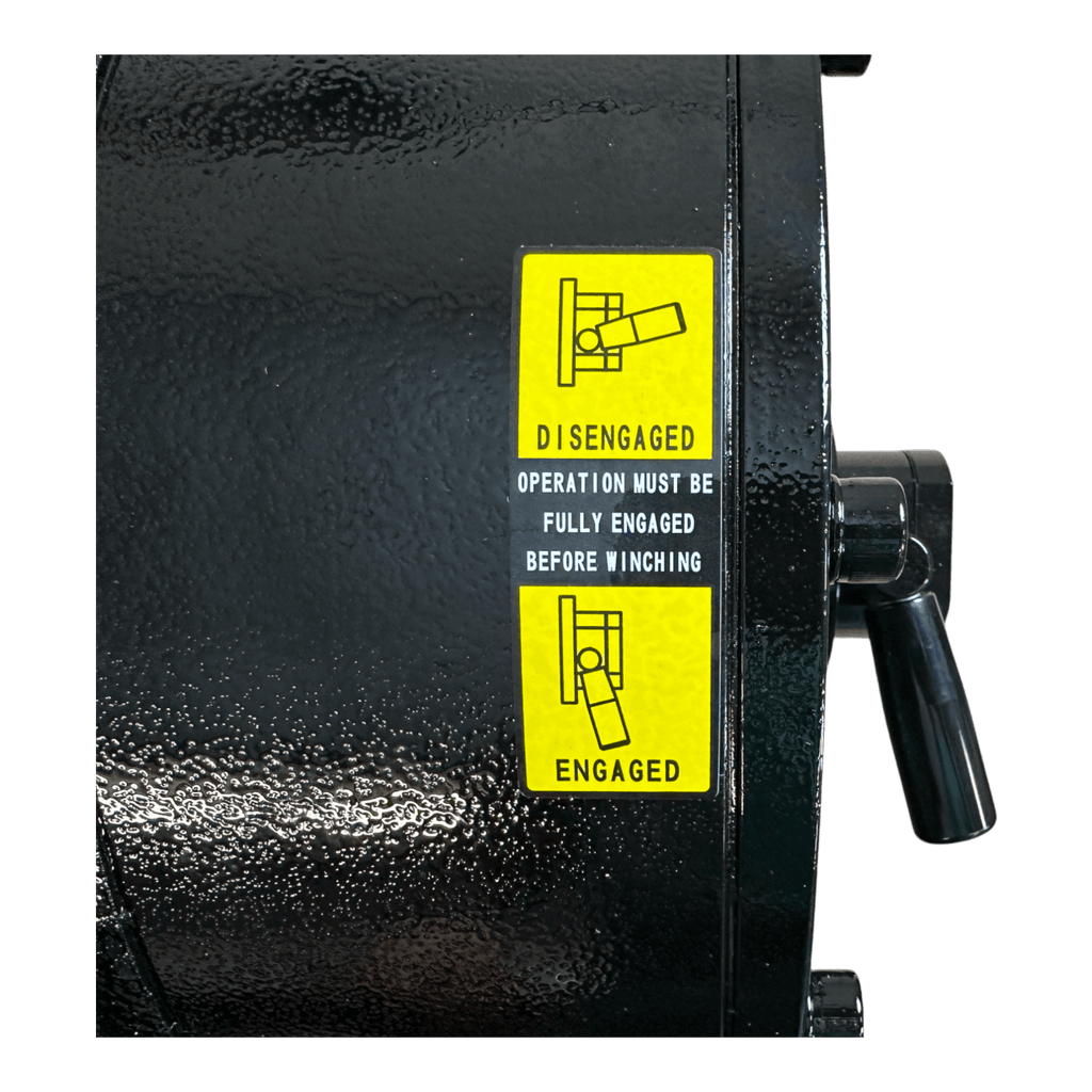 Close-up of the PIERCE 30,000 lb Hydraulic Recovery Winch (Long Drum, Manual Clutch) shows a black winch with a yellow label indicating disengaged and engaged lever positions, designed for heavy recovery operations.