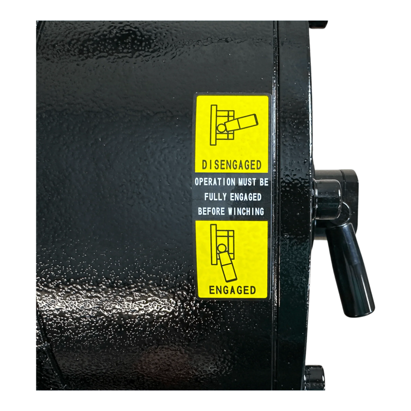 Close-up of a PIERCE 30,000 lb Hydraulic Recovery Winch (Narrow Drum, Manual Clutch) featuring a black finish and a yellow label indicating engaged and disengaged lever positions.