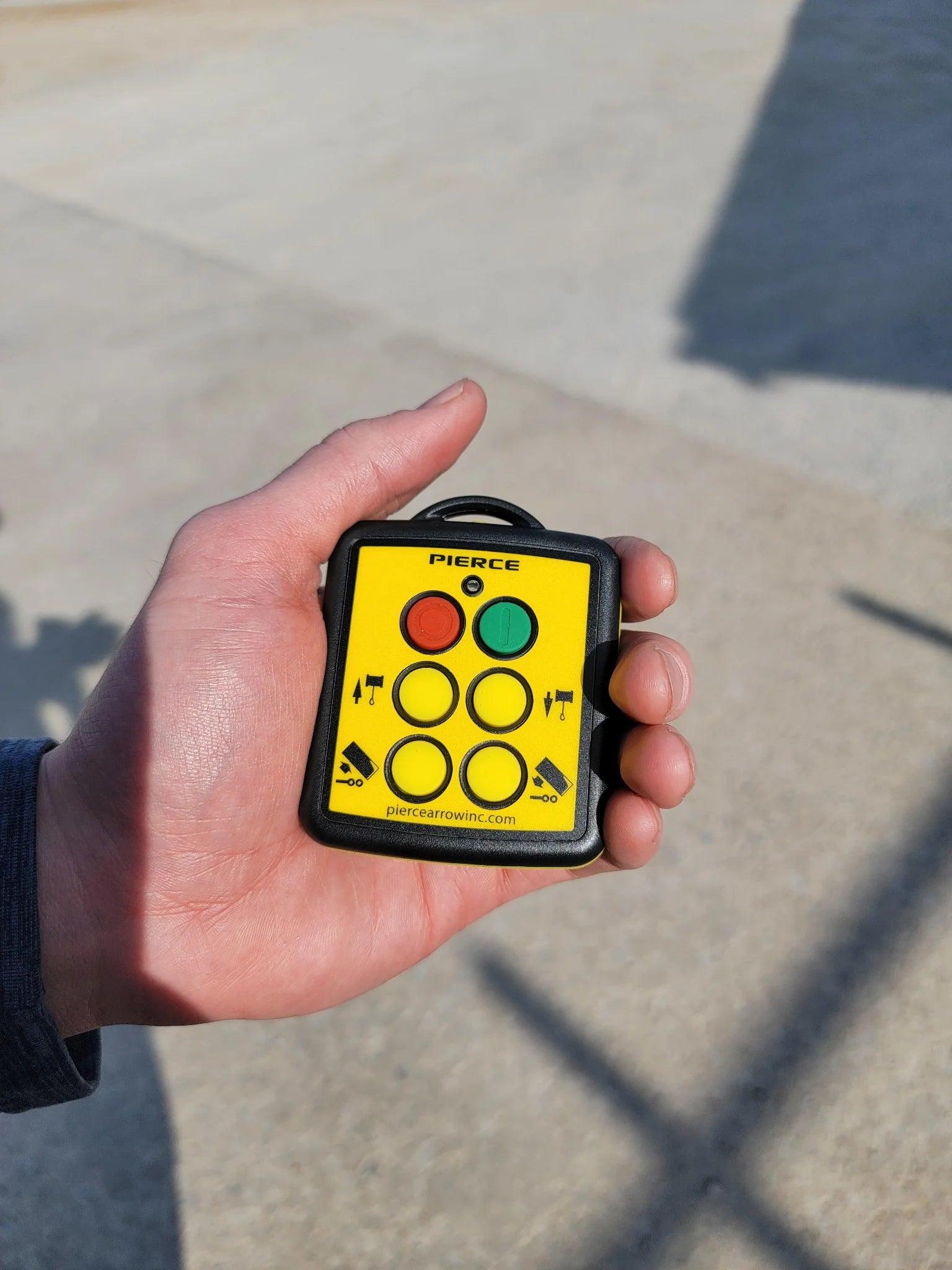 A hand holds a small yellow 4 Function Wireless Remote Transmitter by Lodar LTD featuring buttons, used as a replacement remote in a wireless system.
