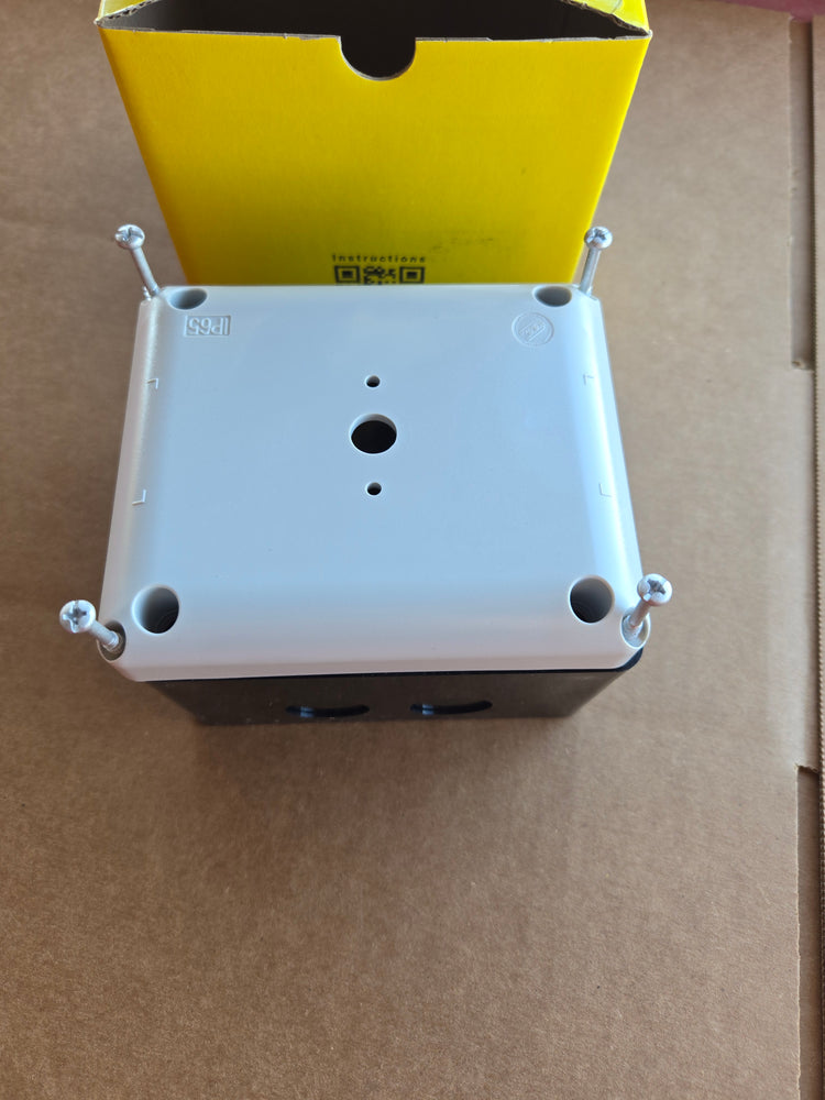 A rectangular PIERCE Control Box for 110V PIERCE 654 Series Single Phase Winch, meant for industrial use, rests on a cardboard box with a yellow package in the background.