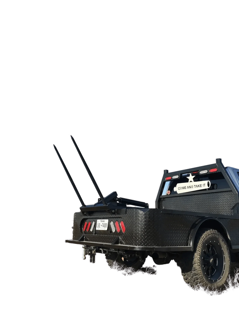 A black pickup with a PIERCE Truck Bed Gooseneck Hay Bale Mover, metal pipes, and a "Come and Take It" sign on the flatbed.