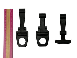 Three PIERCE Coolers Latches in black plastic of varying sizes are placed next to a pink and beige ruler on a white background.