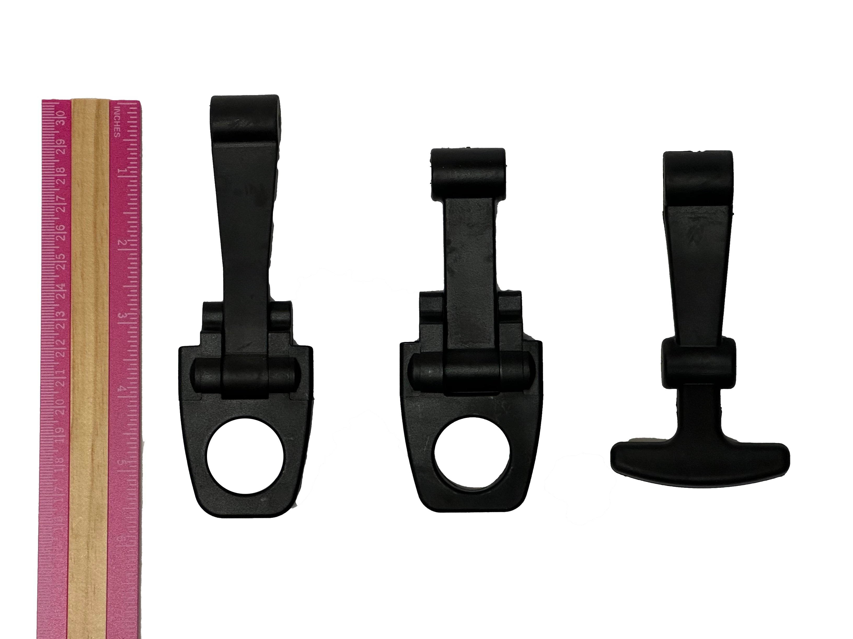 Three PIERCE Coolers Latches in black plastic of varying sizes are placed next to a pink and beige ruler on a white background.