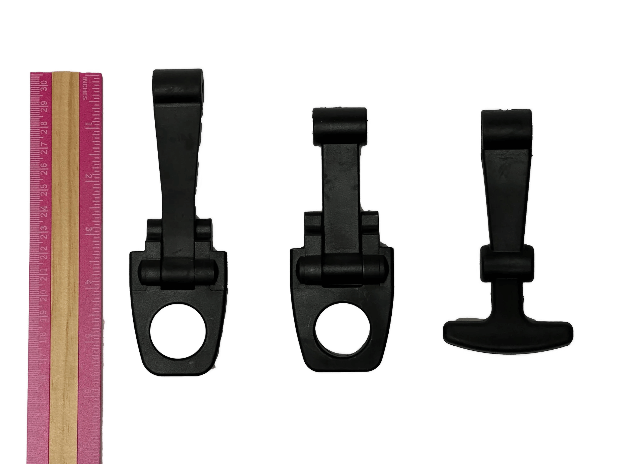 Three PIERCE Coolers Latches in black plastic of varying sizes are placed next to a pink and beige ruler on a white background.