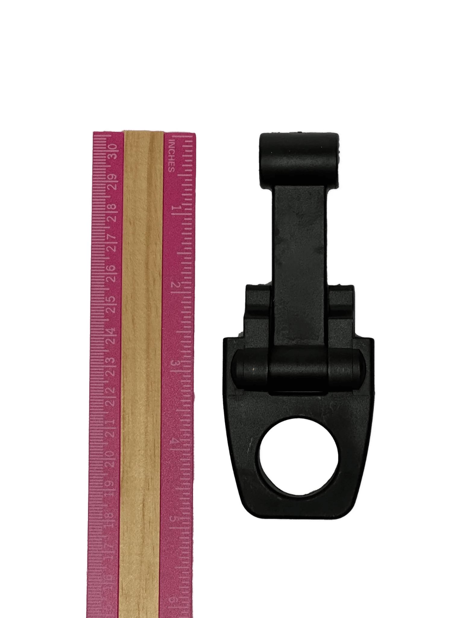 The PIERCE Coolers Latch Version 2, a black plastic clip with a large hole, is shown next to a pink and wood ruler on a white background.