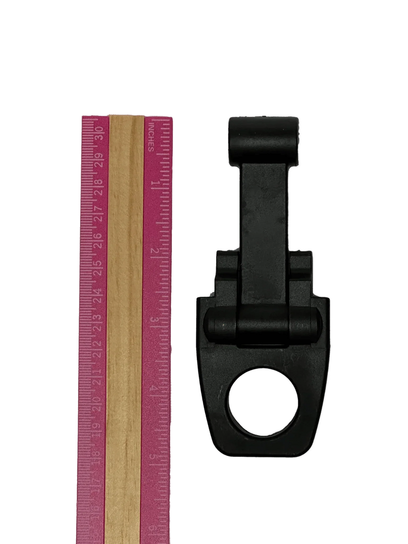 A pink ruler and a PIERCE Coolers Latch Version 2 in black plastic with a round hole, both on a white background.