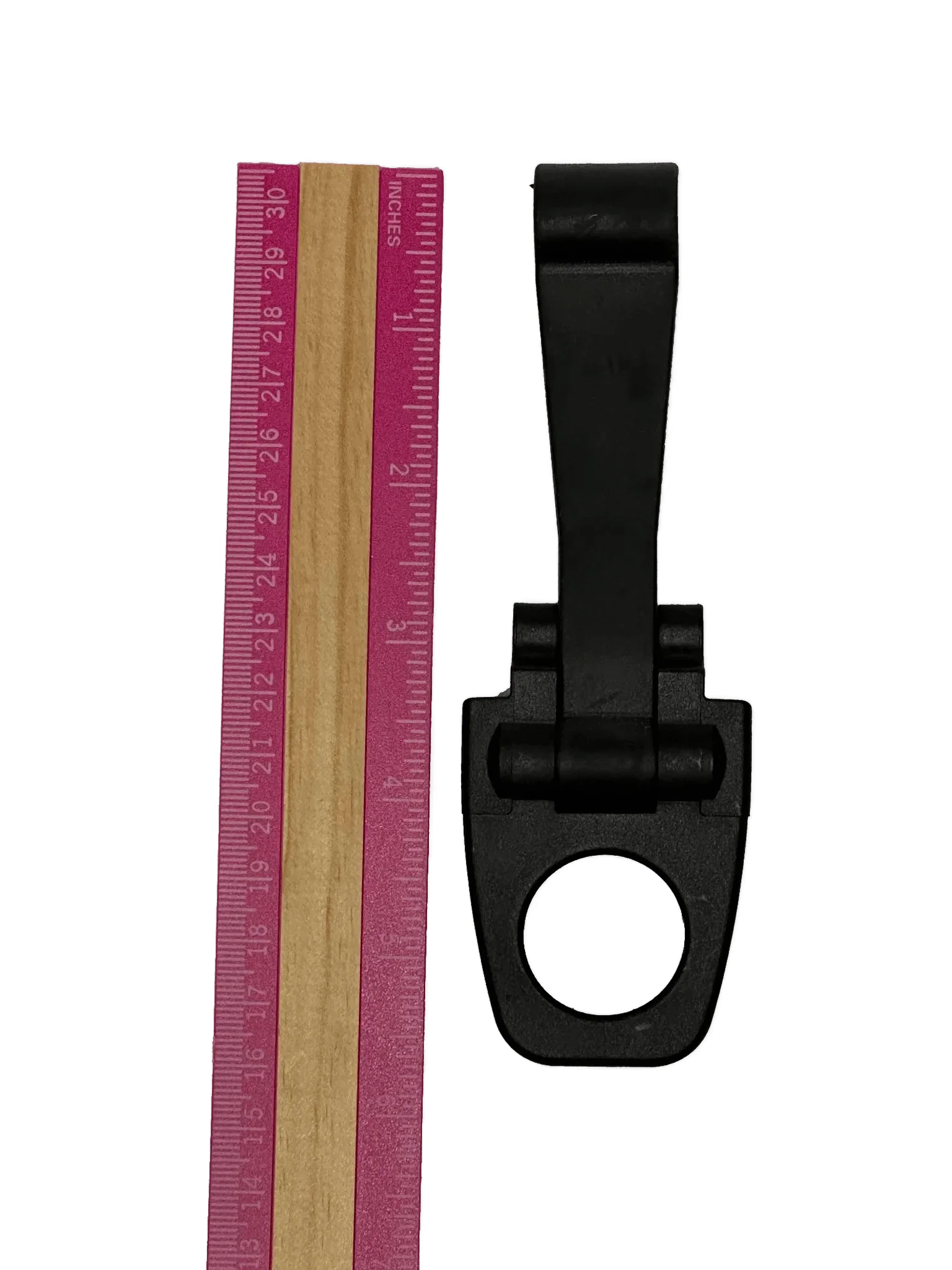 A PIERCE Coolers | Latch | Long | Version 2, black plastic clip with a circular opening, is shown beside a pink and wood ruler on a white background.