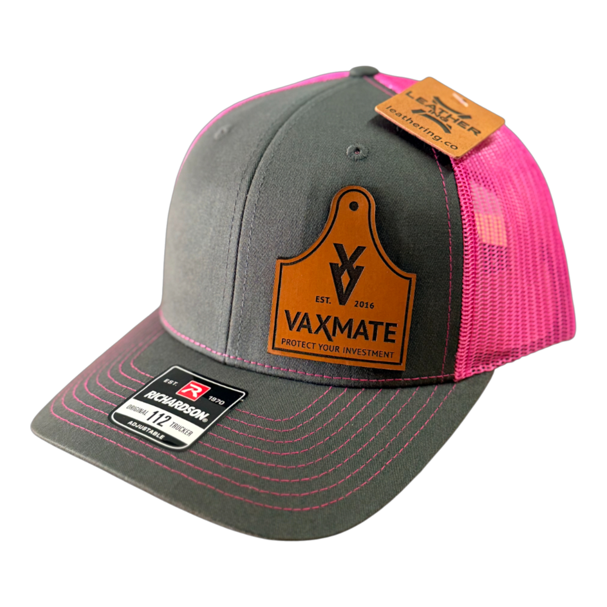 The PIERCE VAXMATE Trucker Hat with Leather Patch features a gray and pink design, a VAXMATE ear tag patch on the front, and comes with brand tags attached.