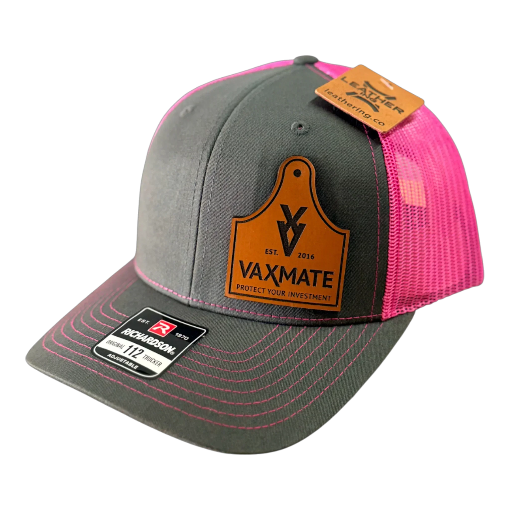The PIERCE VAXMATE Trucker Hat with Leather Patch features gray and pink mesh in the classic Richardson 112 style, complete with a VAXMATE ear tag patch and product tags attached.