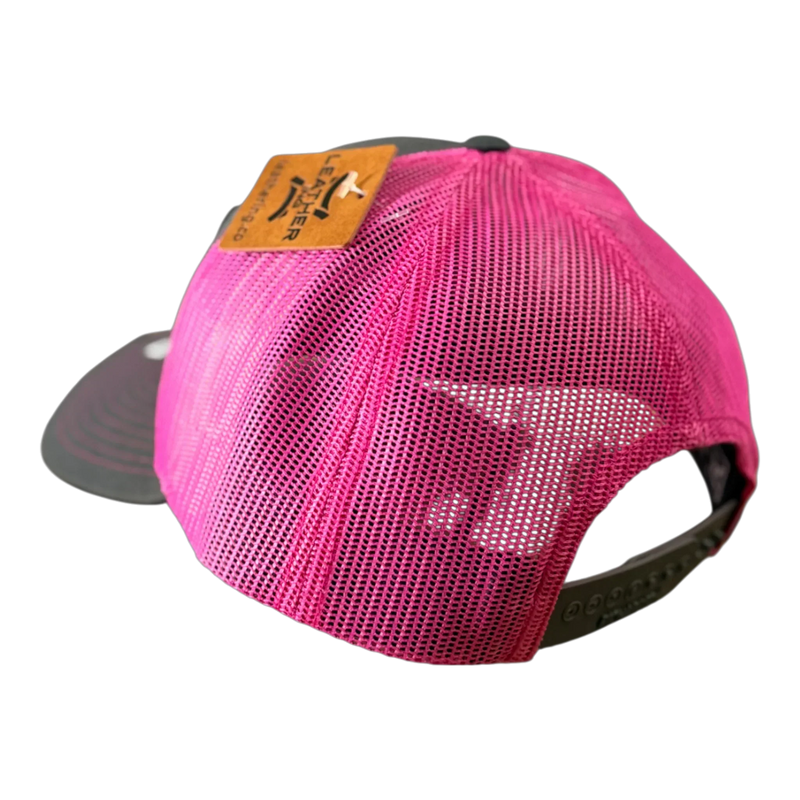 The PIERCE VAXMATE Trucker Hat with Leather Patch in pink mesh is shown from the back, highlighting its adjustable snap closure and brown ear tag patch.
