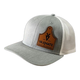 The PIERCE VAXMATE Trucker Hat with Leather Patch is a light gray and white Richardson 112 hat featuring a brown ear tag patch on the front.