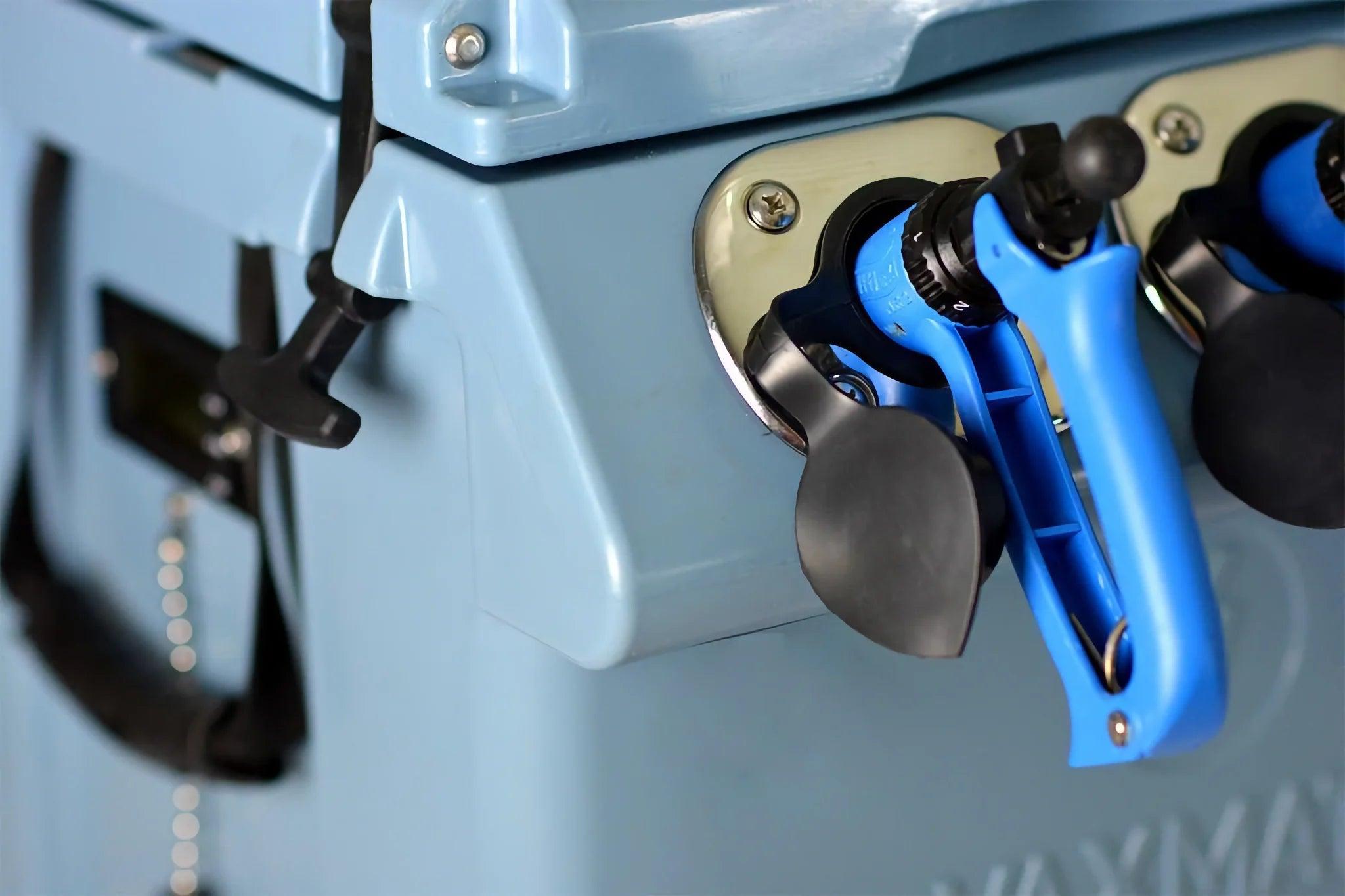 Close-up of two blue and black spigots on a light blue VaxMate Vaccine Cooler by Ningbo Kuer Co., LTD CoolKayak, designed for secure livestock vaccine storage.
